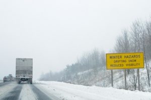Photo shows a transport trailer driving along a snowy highway
